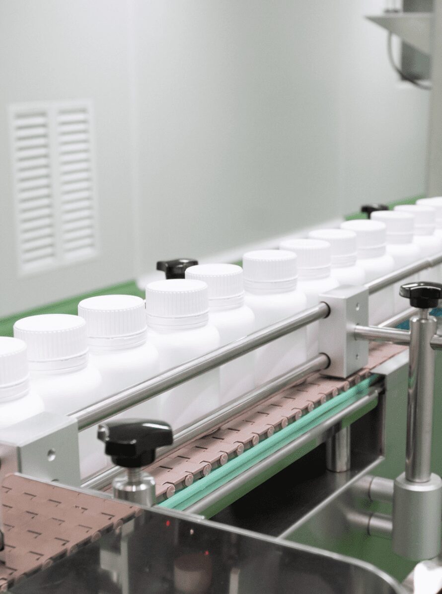 Capped white bottles travelling along the packing conveyor