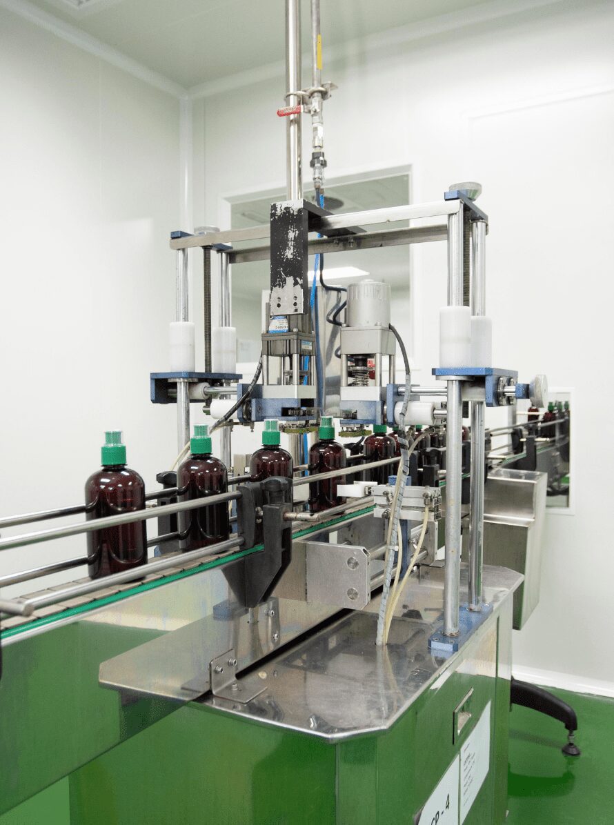 Amber bottles moving through the capping station on the traditional products line
