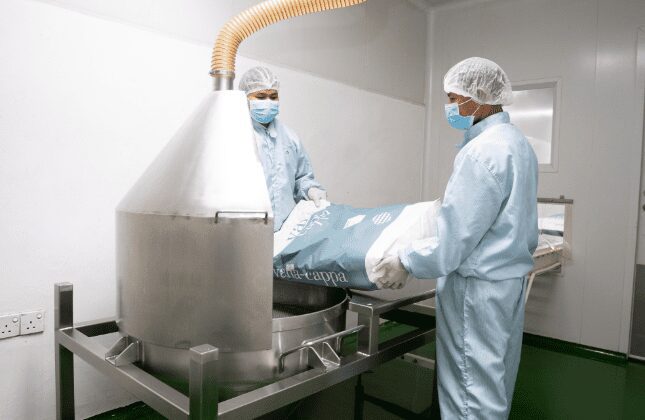 Operators charging powder into the blending hopper