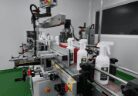 White trigger spray bottles passing through the labelling machine