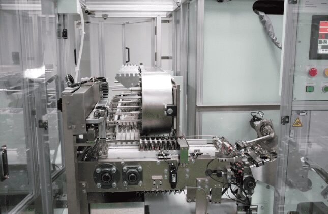 Transfer chain feeding the cartoning machine