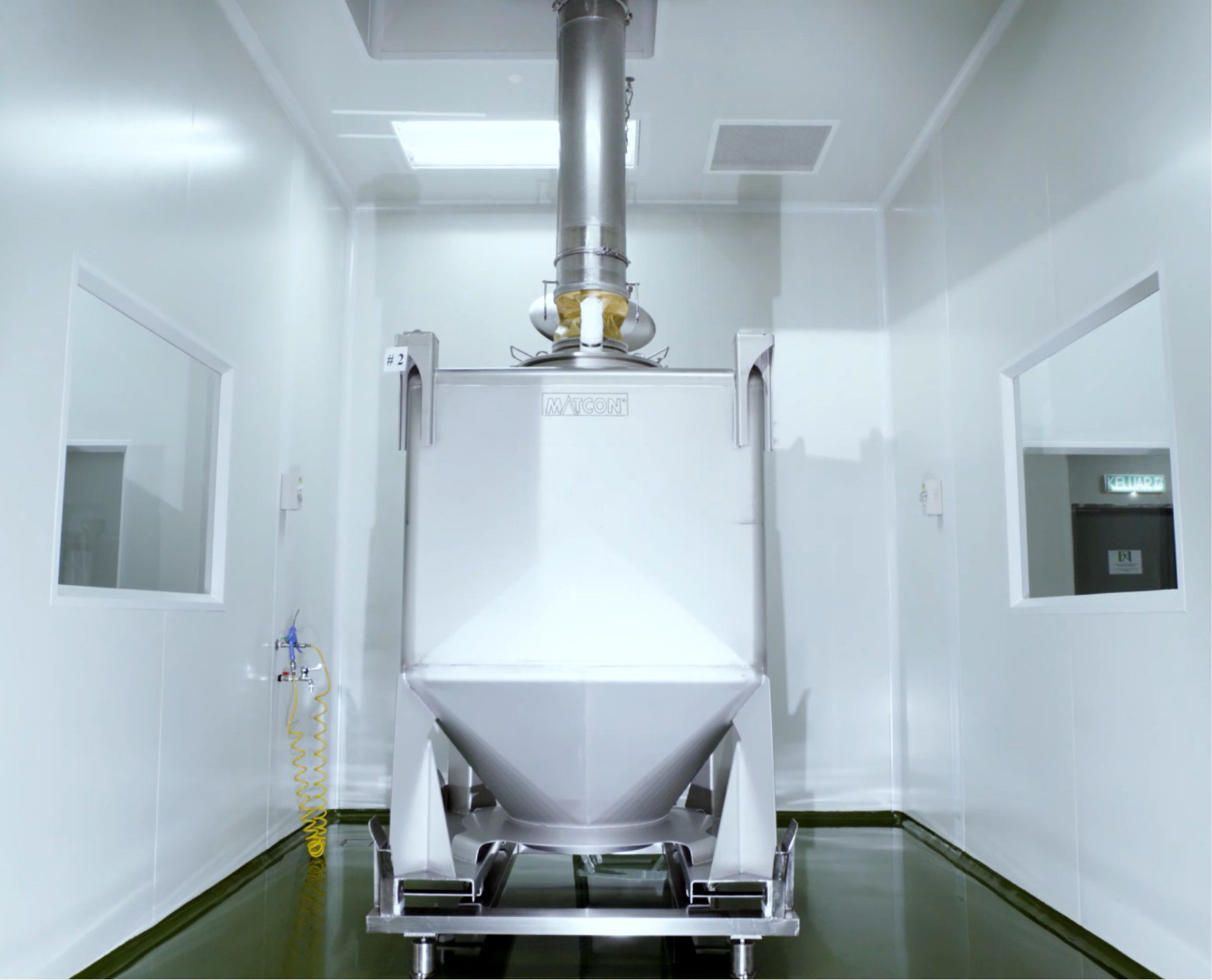 Gravity discharge hopper feeding product between cleanroom floors