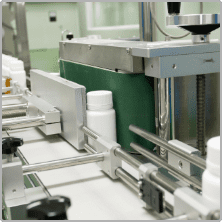 Automatic capping head sealing bottles on the A Block production line
