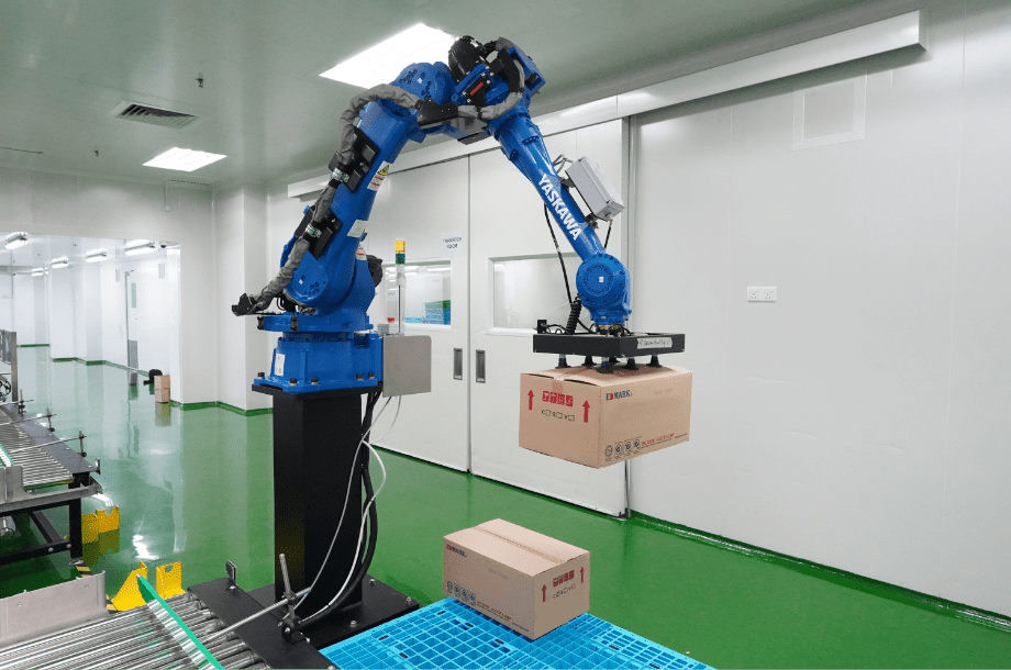 Robotic palletising arm stacking finished cartons at the end of the line