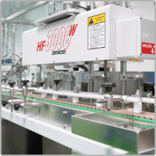 Labelling machine applying labels to bottles in D Block