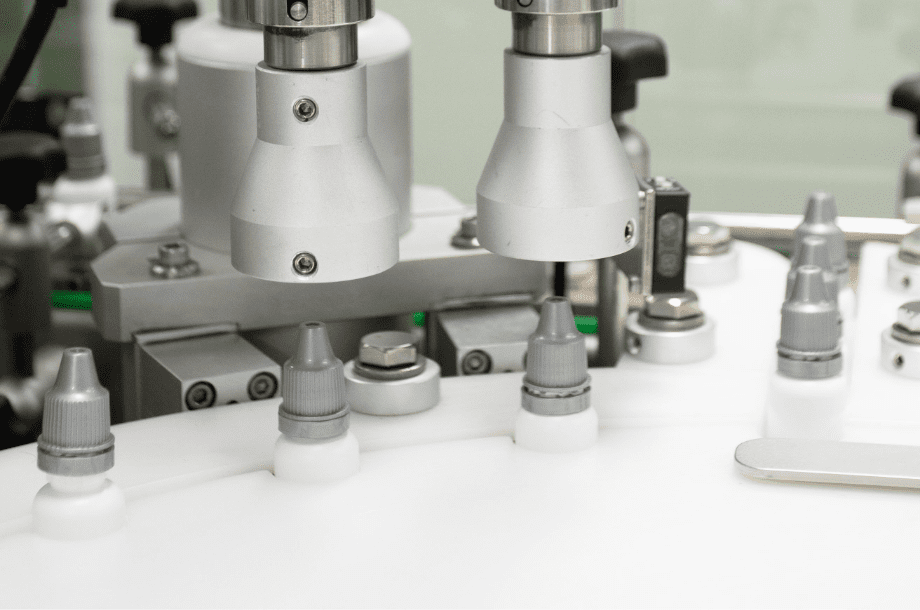 Automatic capping heads sealing bottles on the D Block line