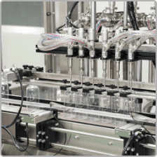 Multi-head liquid filling machine filling clear bottles