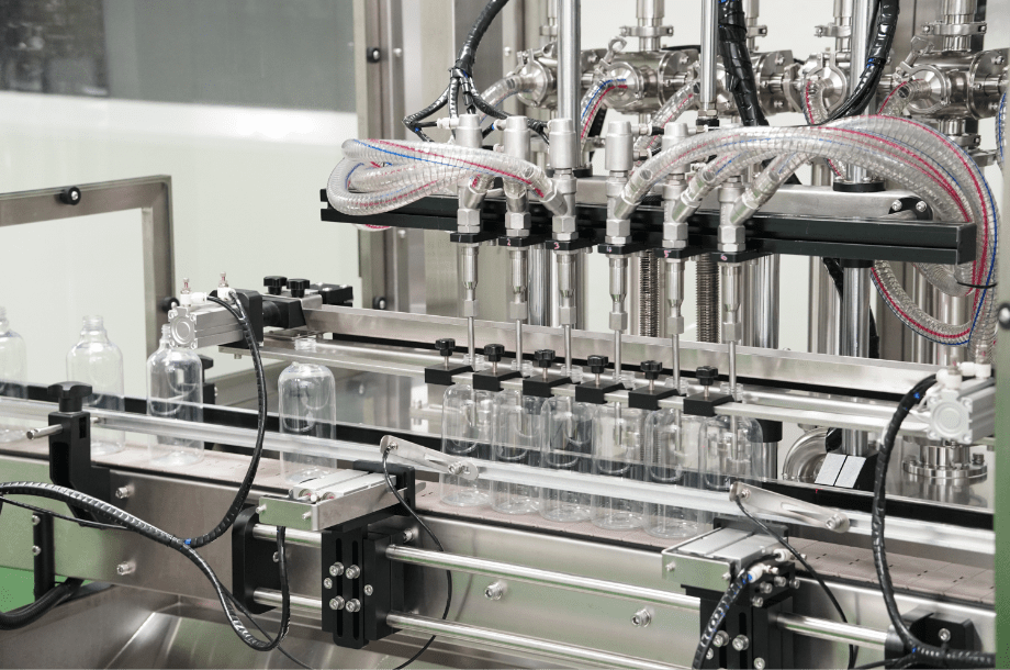 Multi-head liquid filling machine filling clear bottles