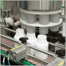 White HDPE bottles passing through the automatic capping unit