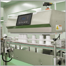 Capped white bottles travelling along the packing conveyor
