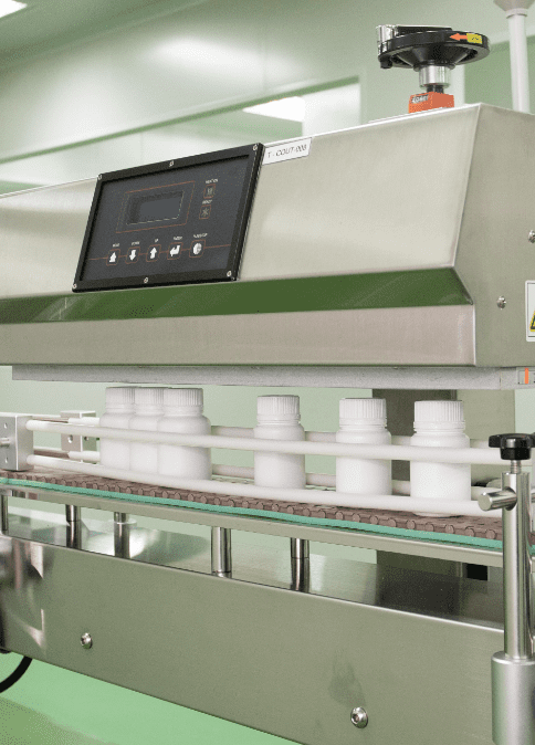 Capped white bottles travelling along the packing conveyor