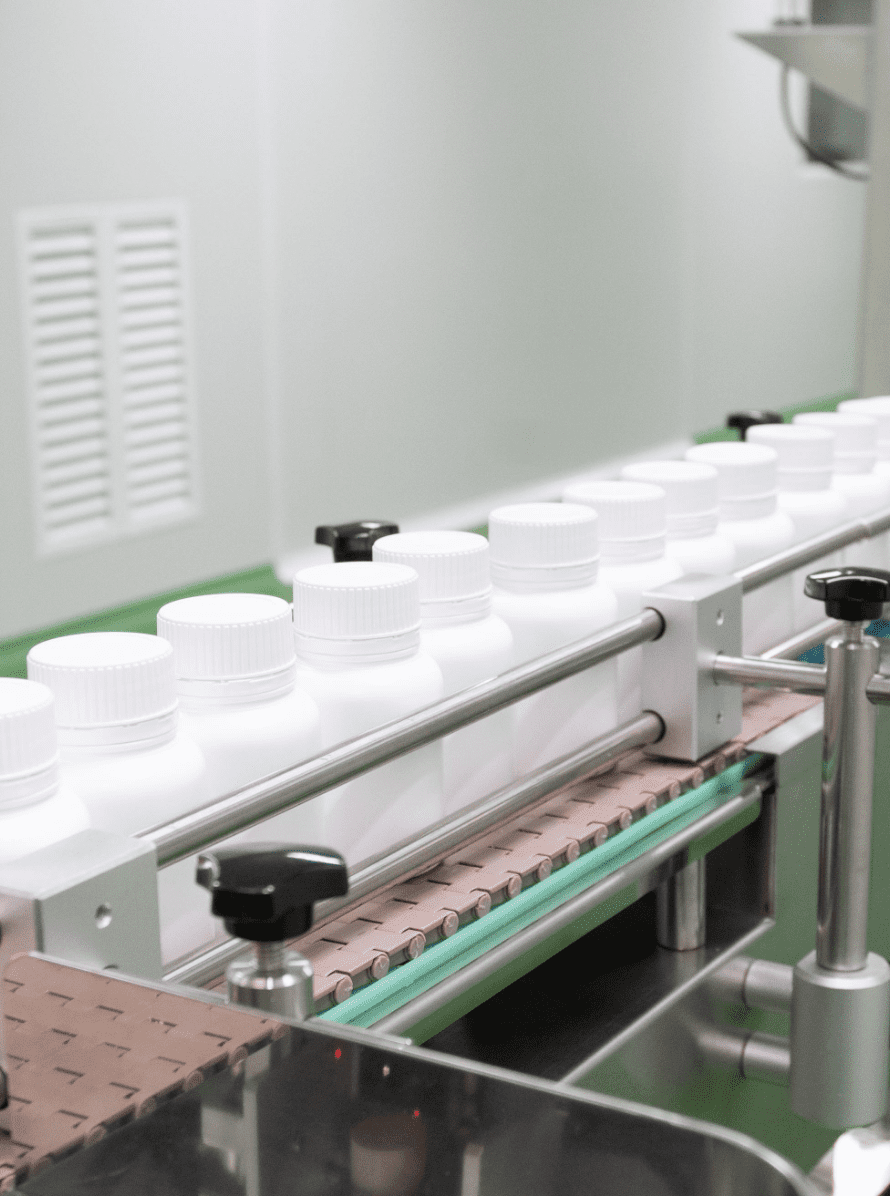 Capped white bottles travelling along the packing conveyor