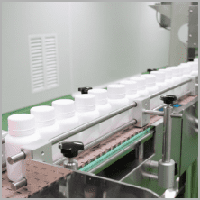 White bottles on the conveyor of the traditional products packing line