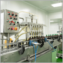Multi-head filling machine filling amber bottles with traditional herbal liquid