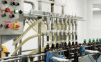 Multi-head filling machine filling amber bottles with traditional herbal liquid