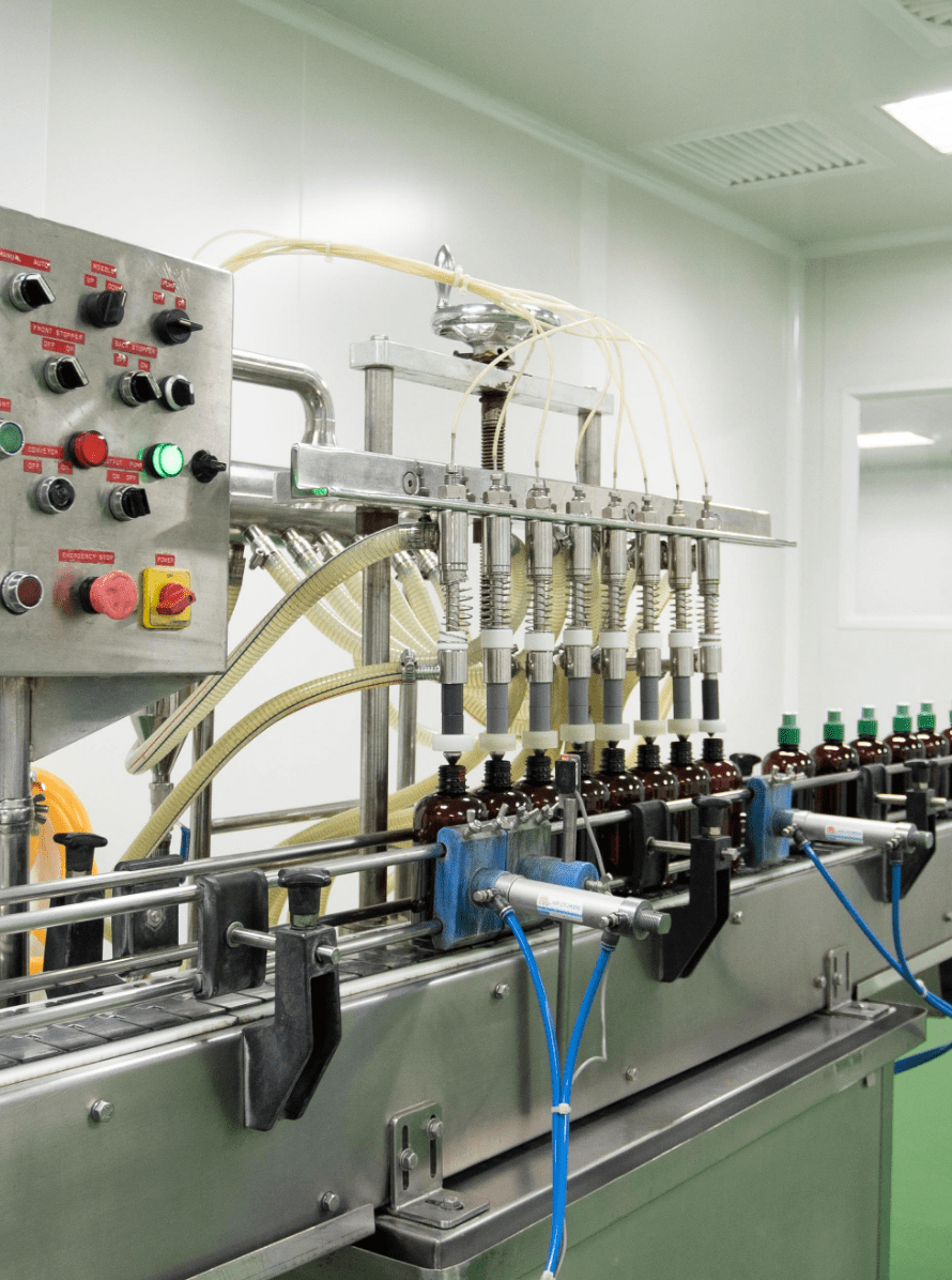 Multi-head filling machine filling amber bottles with traditional herbal liquid