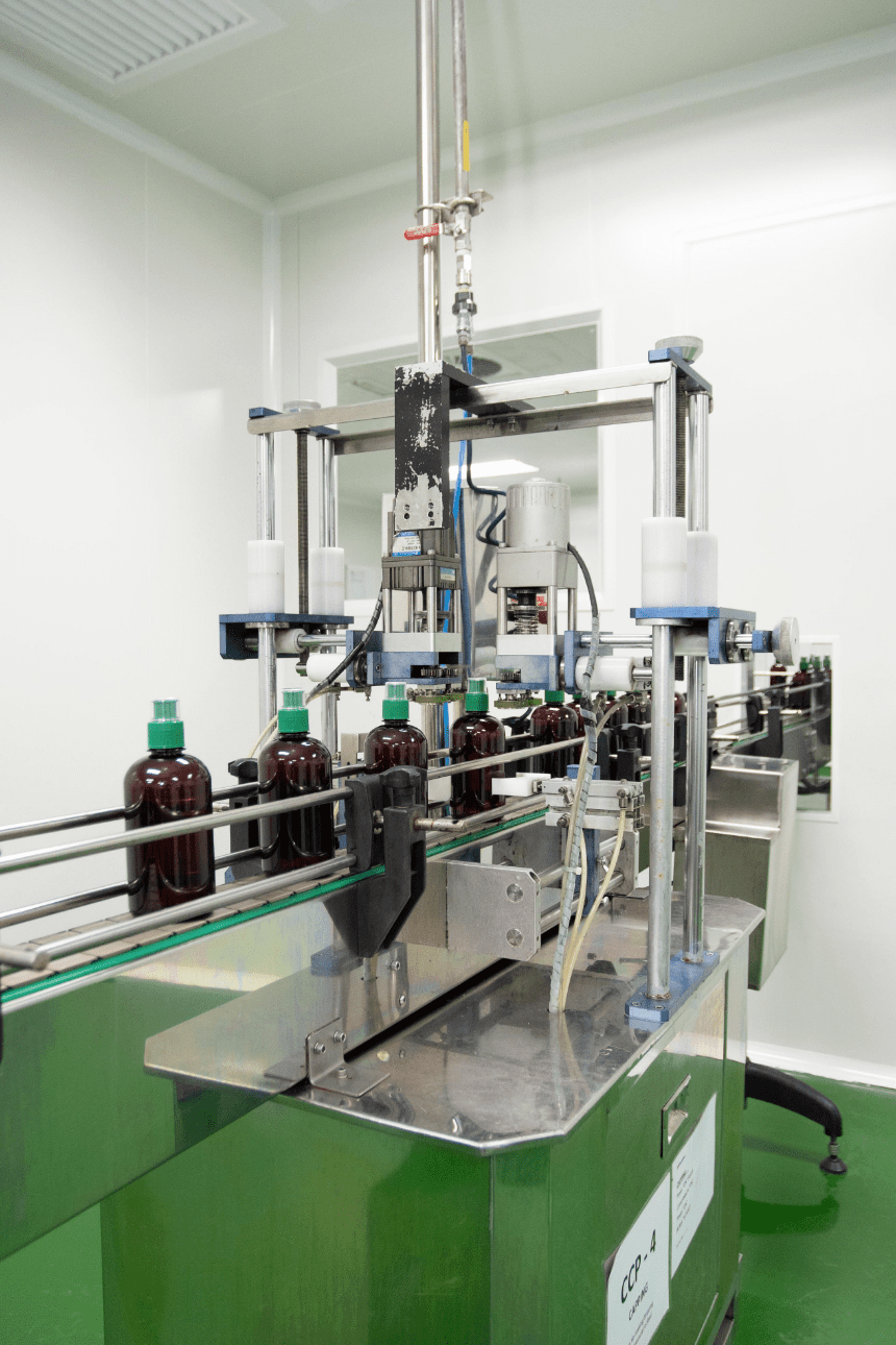 Amber bottles moving through the capping station on the traditional products line