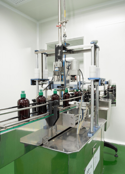 Amber bottles moving through the capping station on the traditional products line