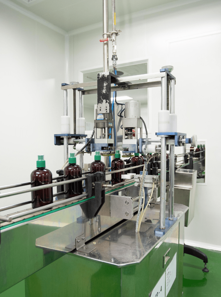 Amber bottles moving through the capping station on the traditional products line