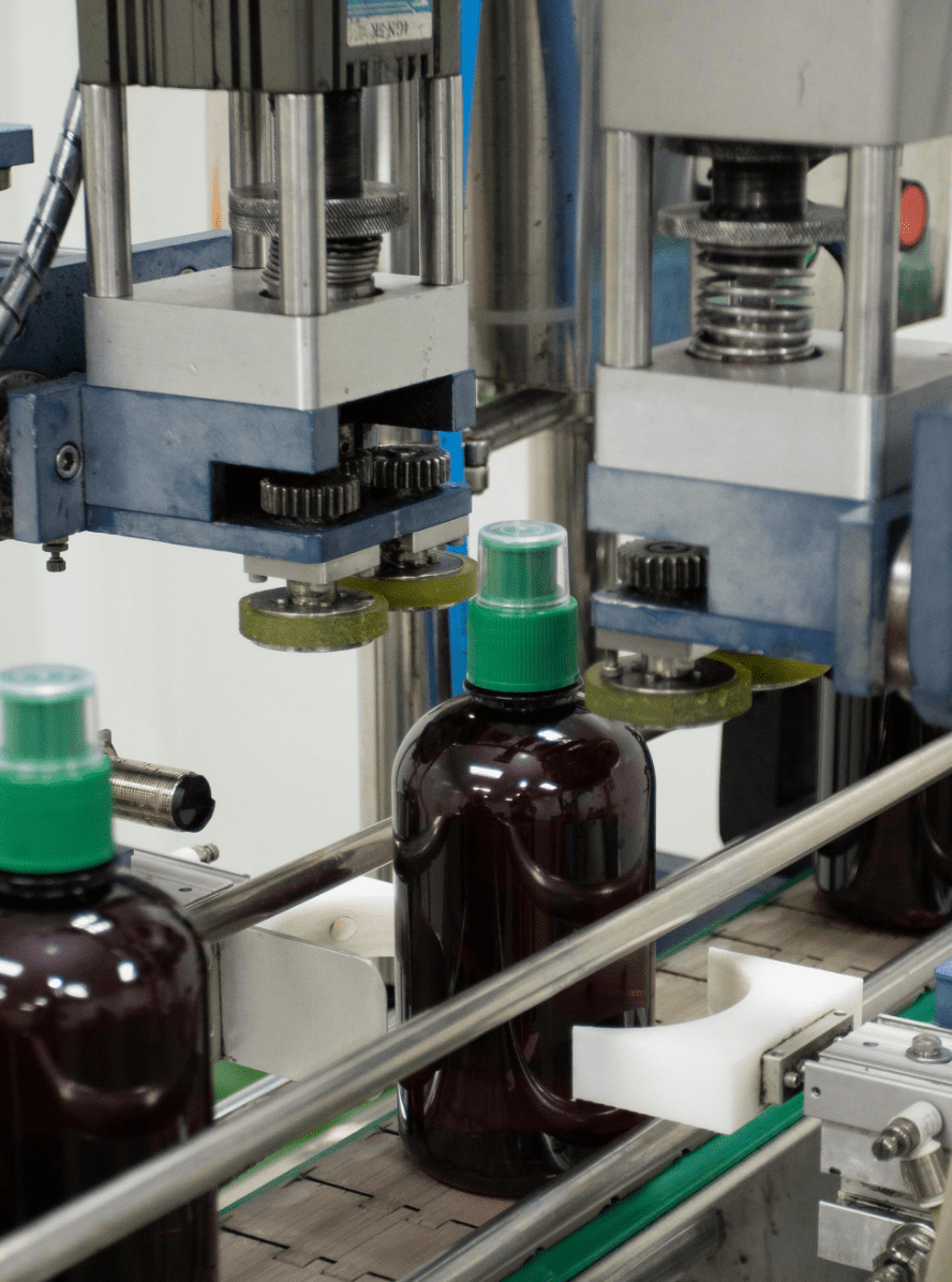 Automatic capping head sealing an amber bottle of herbal liquid