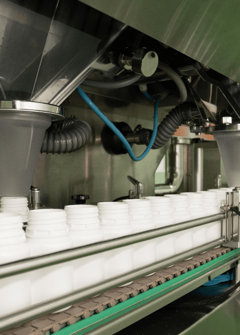 Automatic filling machine dosing product into white containers