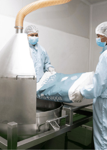 Operators charging powder into the blending hopper