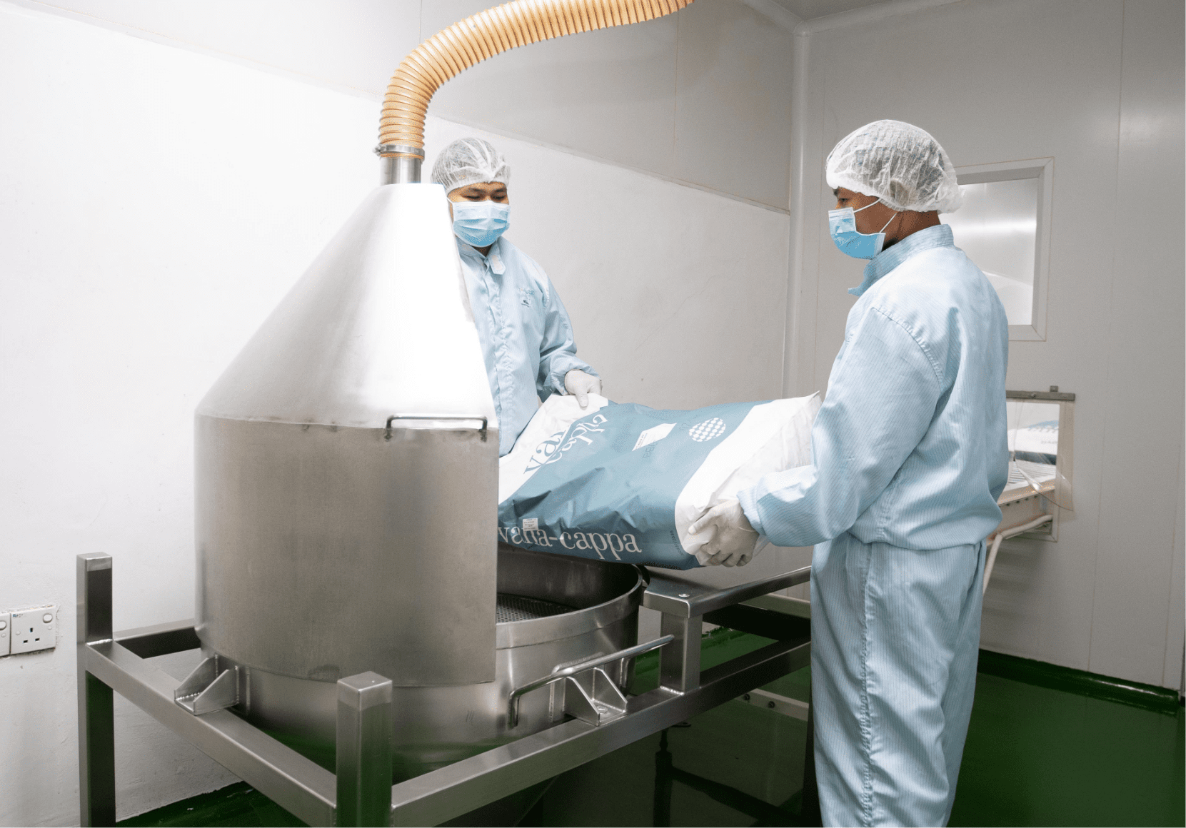 Operators charging powder into the blending hopper