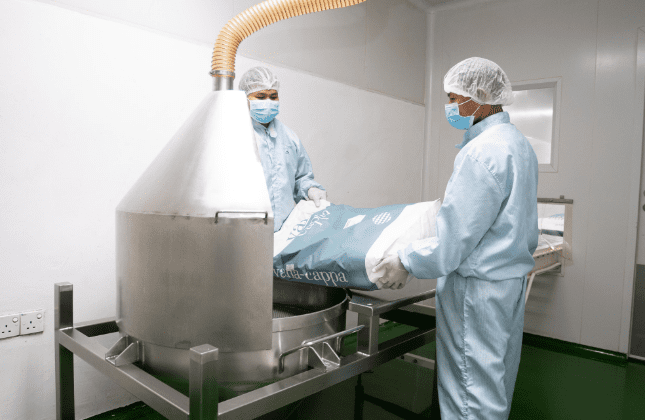 Operators charging powder into the blending hopper
