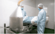Operators charging powder into the blending hopper