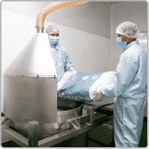 Operators charging powder into the blending hopper