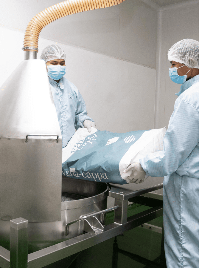 Operators charging powder into the blending hopper
