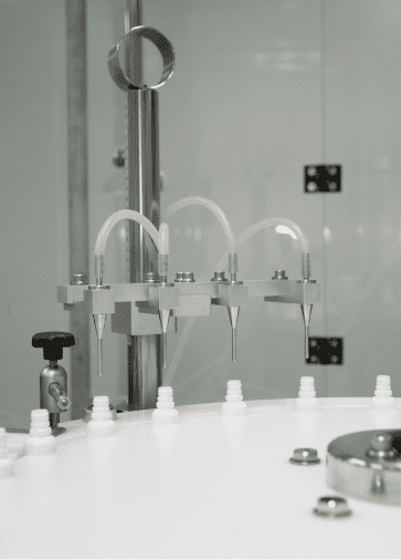 Filling nozzles dosing liquid into white bottles