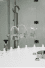 Filling nozzles dosing liquid into white bottles