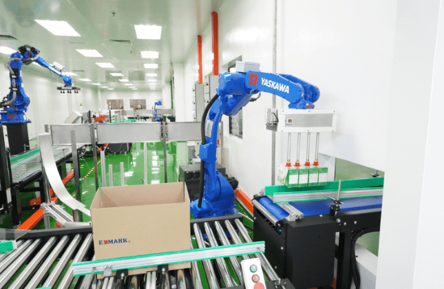 Robotic arm case-packing products into a carton on the roller conveyor