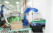 Robotic arm case-packing products into a carton on the roller conveyor