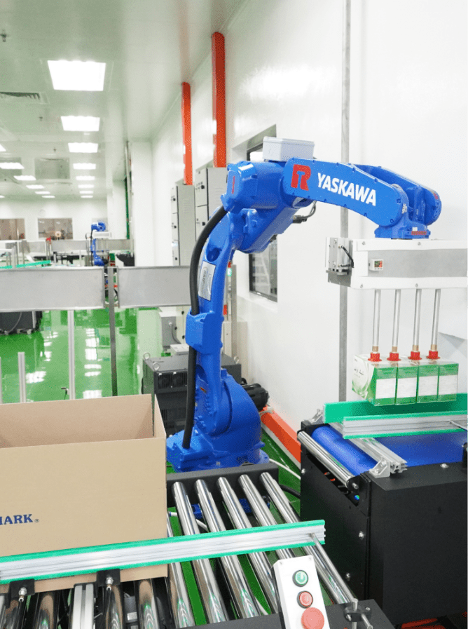 Robotic arm case-packing products into a carton on the roller conveyor