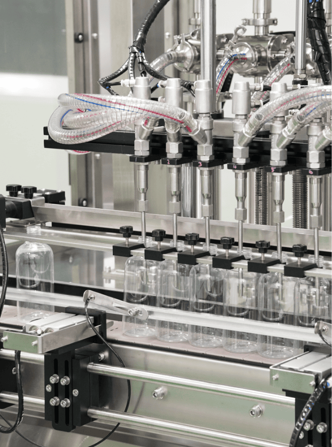 Clear spray bottles under the filling nozzles on the home care line