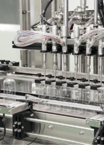 Clear spray bottles under the filling nozzles on the home care line