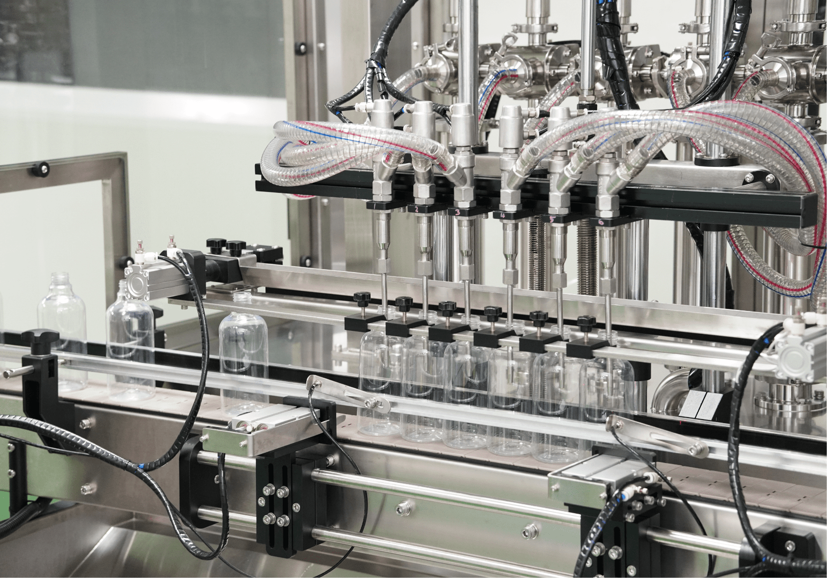 Clear spray bottles under the filling nozzles on the home care line