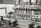 Clear spray bottles under the filling nozzles on the home care line