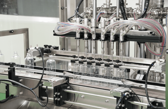Clear spray bottles under the filling nozzles on the home care line