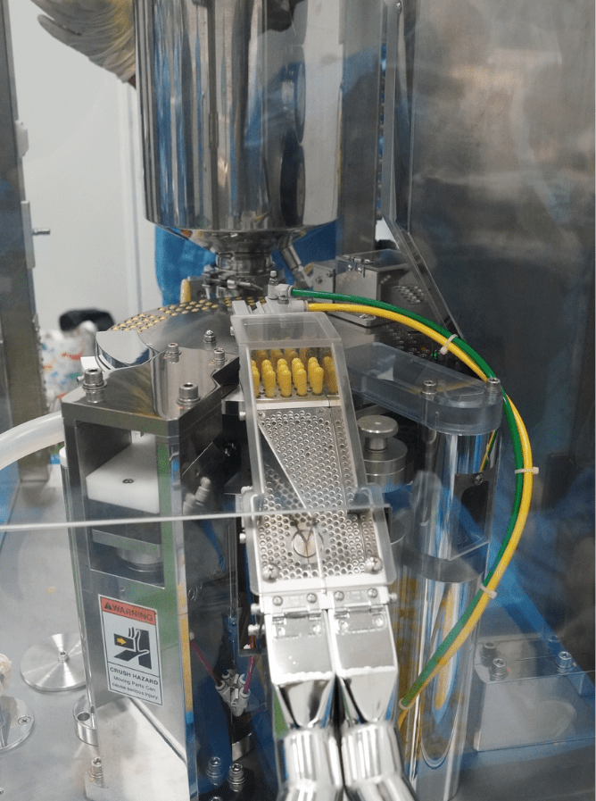 Capsule feed channel on the filling machine