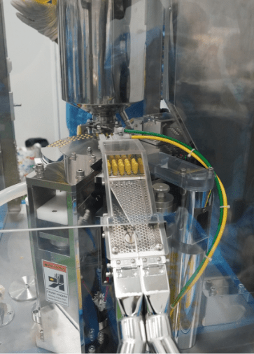 Capsule feed channel on the filling machine