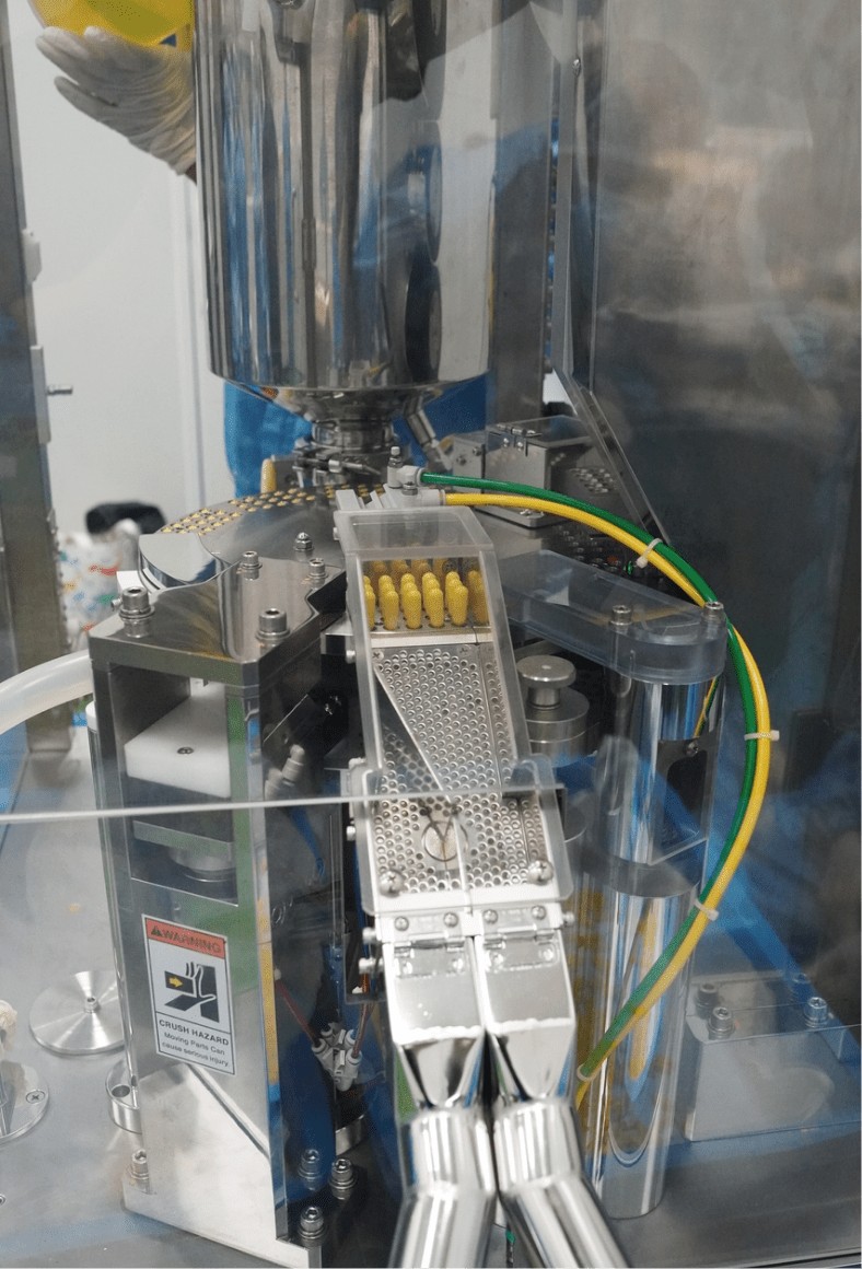 Capsule feed channel on the filling machine