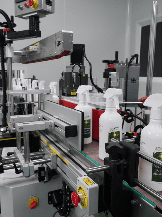 White trigger spray bottles passing through the labelling machine