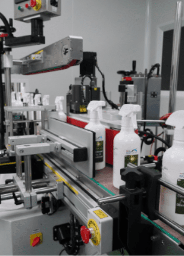White trigger spray bottles passing through the labelling machine