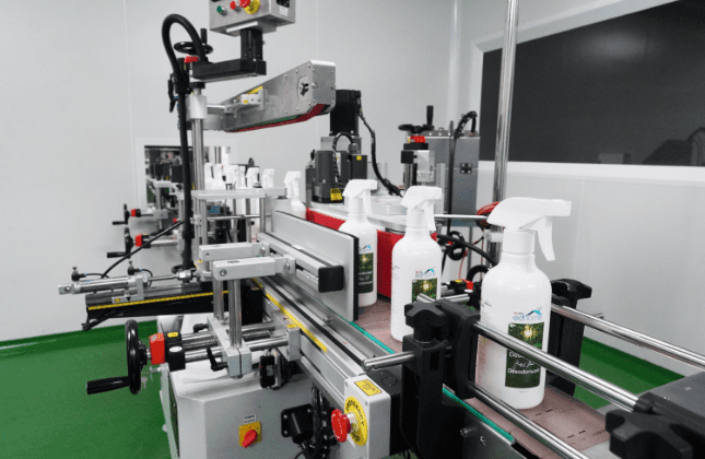 White trigger spray bottles passing through the labelling machine