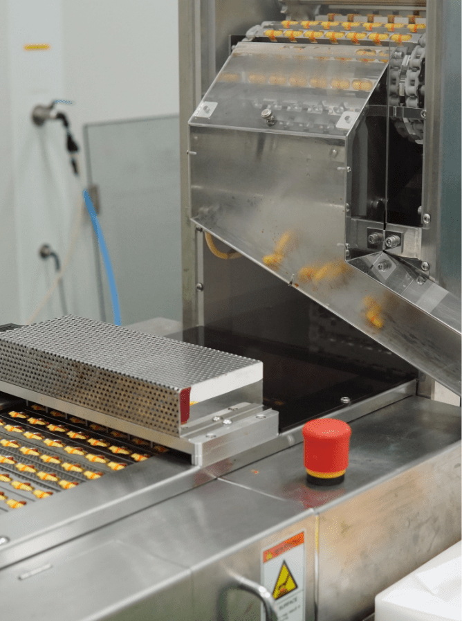 Softgel capsules on the discharge chute of the encapsulation machine