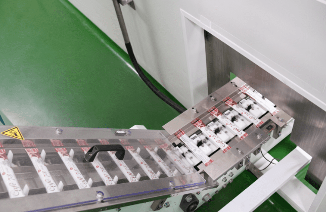 Sachet strips on the transfer conveyor to cartoning