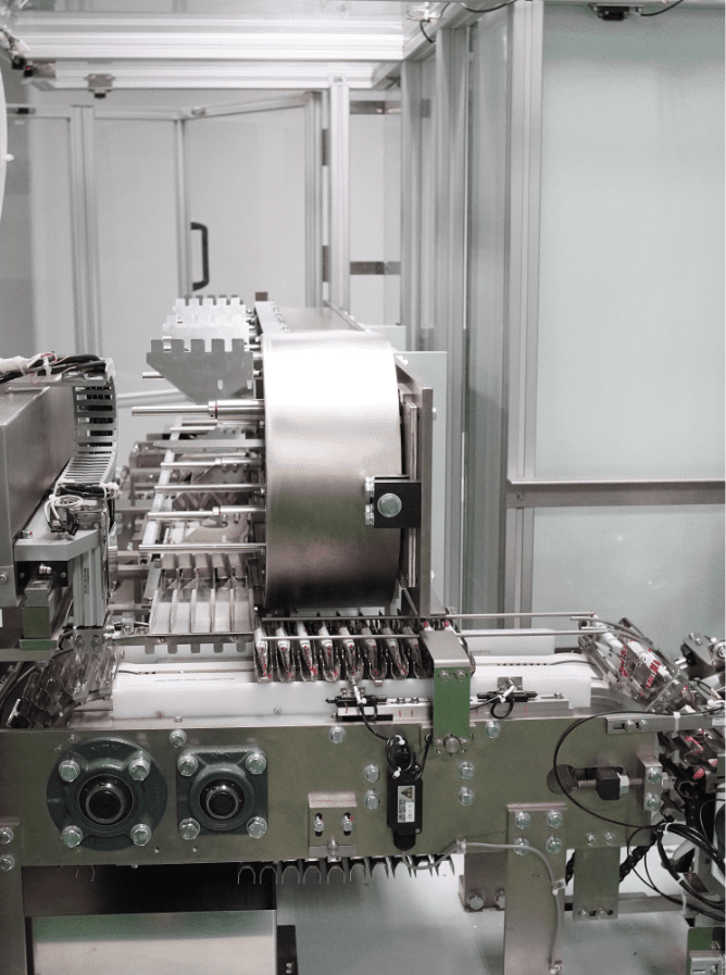 Transfer chain feeding the cartoning machine